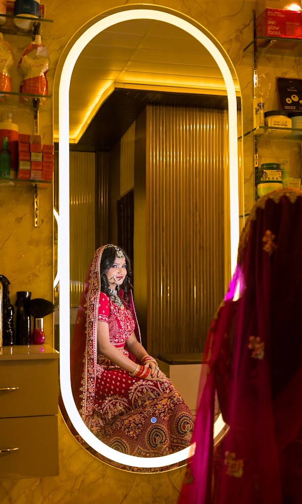 Bride in a red lehenga seated at the studio's LED arch mirror